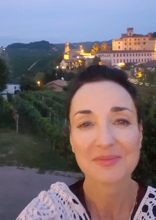 Kerin O'Keefe with Nebbiolo vineyards and Barolo Castle in the background